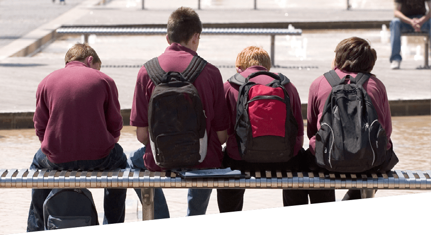 Group of teenage boys sat inactive on a bench